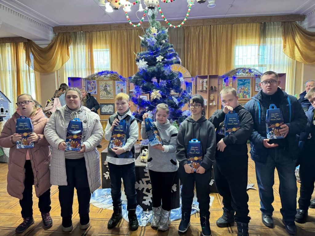 Disabled children holding chocolate gift sets at a concert organised by charities Sunflower Scotland (UK) and Shira Sprava (Ukraine) in Kryvyi Rih