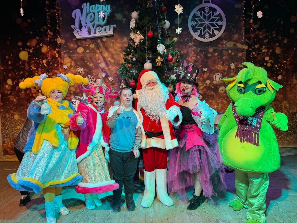 Disabled Ukrainian boy showing thumbs up with Santa Claus and actors at a concert organised by charities Sunflower Scotland (UK) and Shira Sprava (Ukraine) in Kryvyi Rih