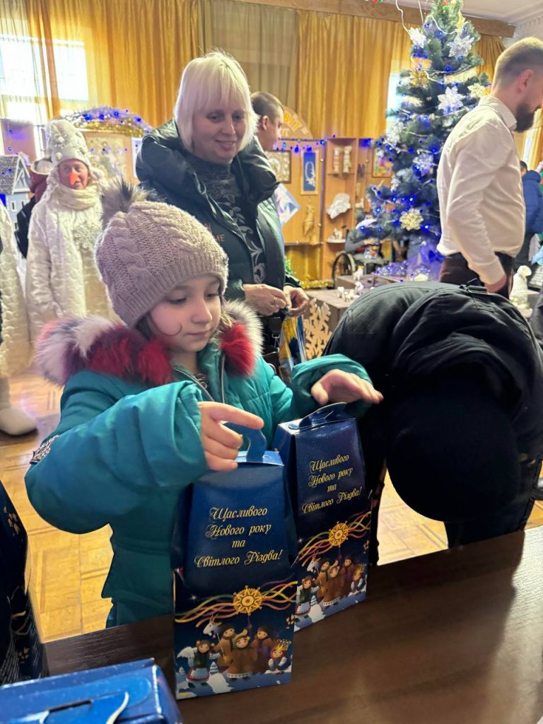 Ukrainian girl receiving a chocolate gift set at a concert organised by charities Sunflower Scotland (UK) and Shira Sprava (Ukraine) in Kryvyi Rih