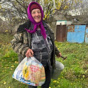 A resident of Fedorivka village, Kherson Oblast, holding humanitarian aid from Sunflower Scotland