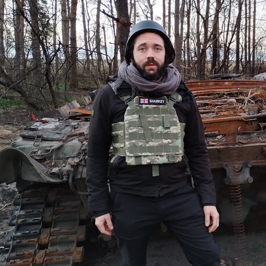 David Sharkey in front of a burnt Russian tank, near Izium, Ukraine, Nov 2022