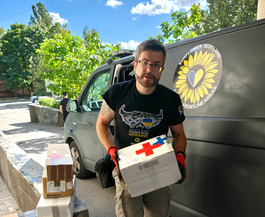 Oleg Dmitriev unloading medical supplies from a van, as Sunflower donates medical supplies to a hospital in Sumy