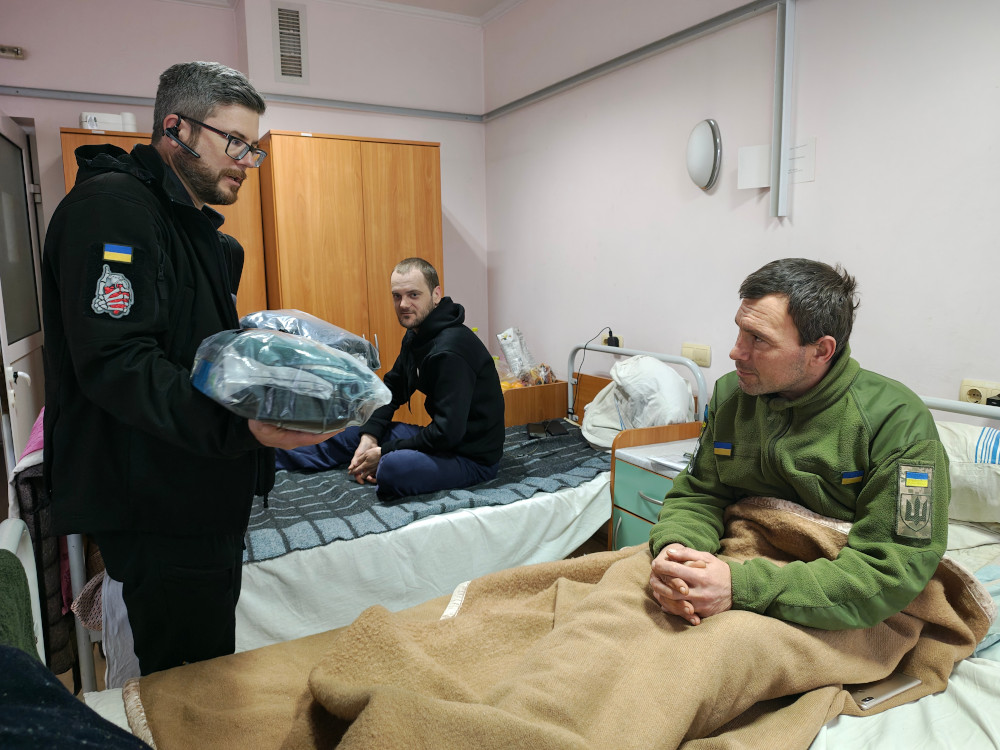 Sunflower donating clothing to a wounded soldier in Kharkiv hospital