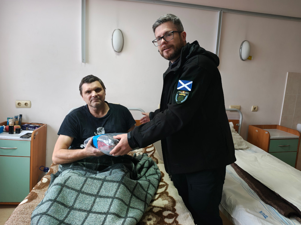 Sunflower donating clothing to a wounded soldier in Kharkiv hospital