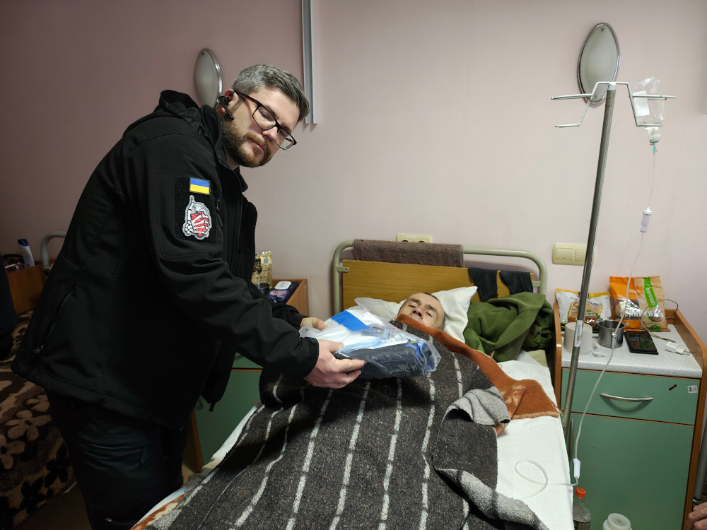 Sunflower donating clothing to a wounded soldier in Kharkiv hospital
