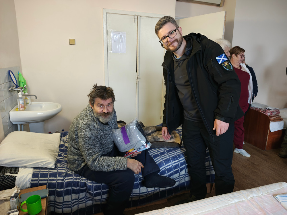 Sunflower donating clothing to a wounded soldier in Kharkiv hospital