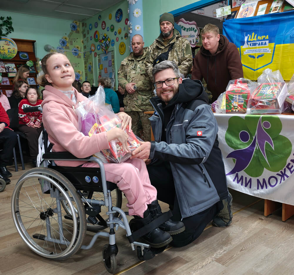 A child with special needs in Kryvyi Rih receiving a Christmas gift from Sunflower Scotland