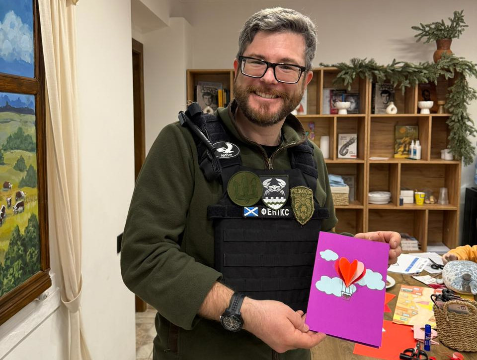 Oleg holsing his Valentine's card he made for his wife at KRYLA art hub in Kherson