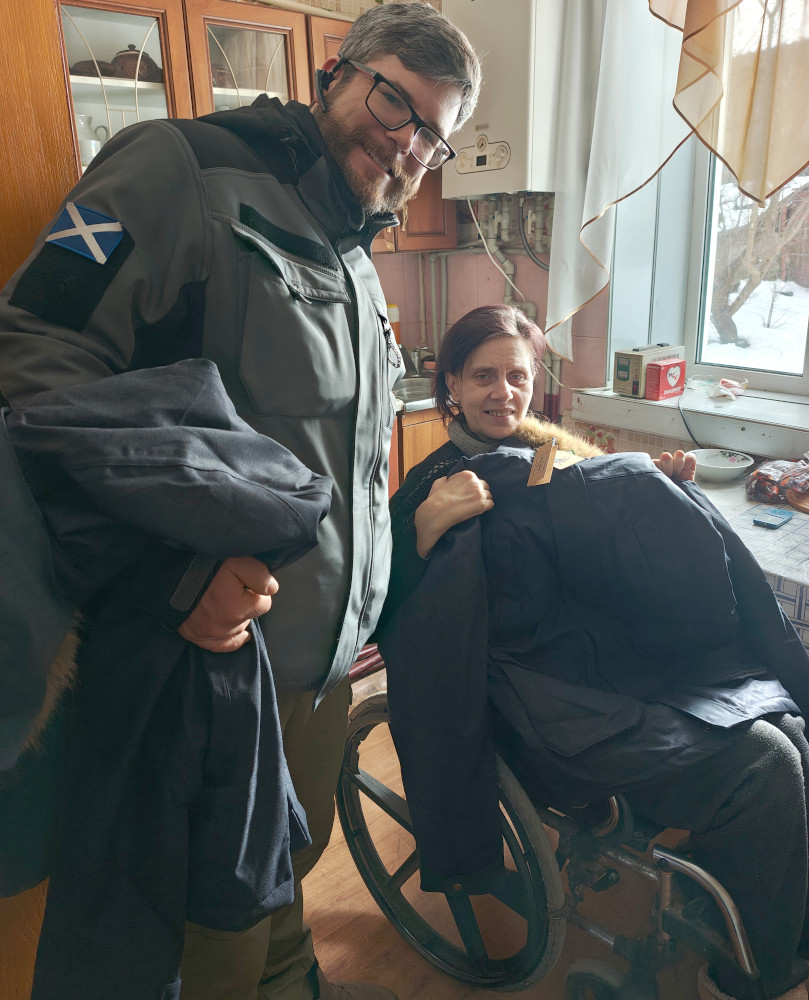 Disabled person in wheelchair in Sumy region receiving jacket from Hoggs of Fife