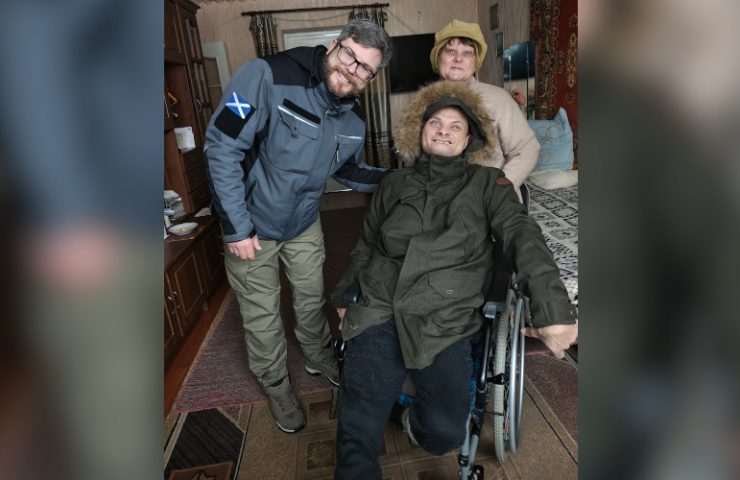Disabled person in wheelchair in Sumy region reciving jacket from Hoggs of Fife
