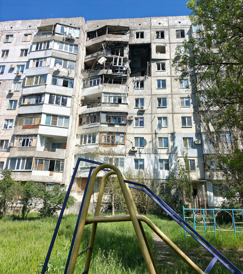 Children's playground in front of block of flats damaged by Russian missile in Kherson