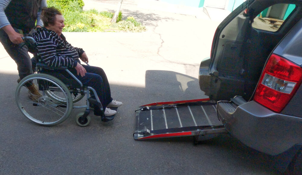 Loading a patient into Social Taxi wheelchair car donated by Sunflower Scotland
