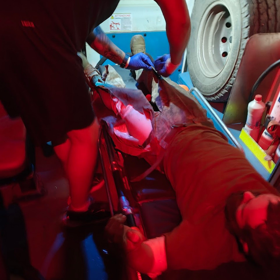 Paramedic cutting off uniform with shears from a wounded soldier in an ambulance